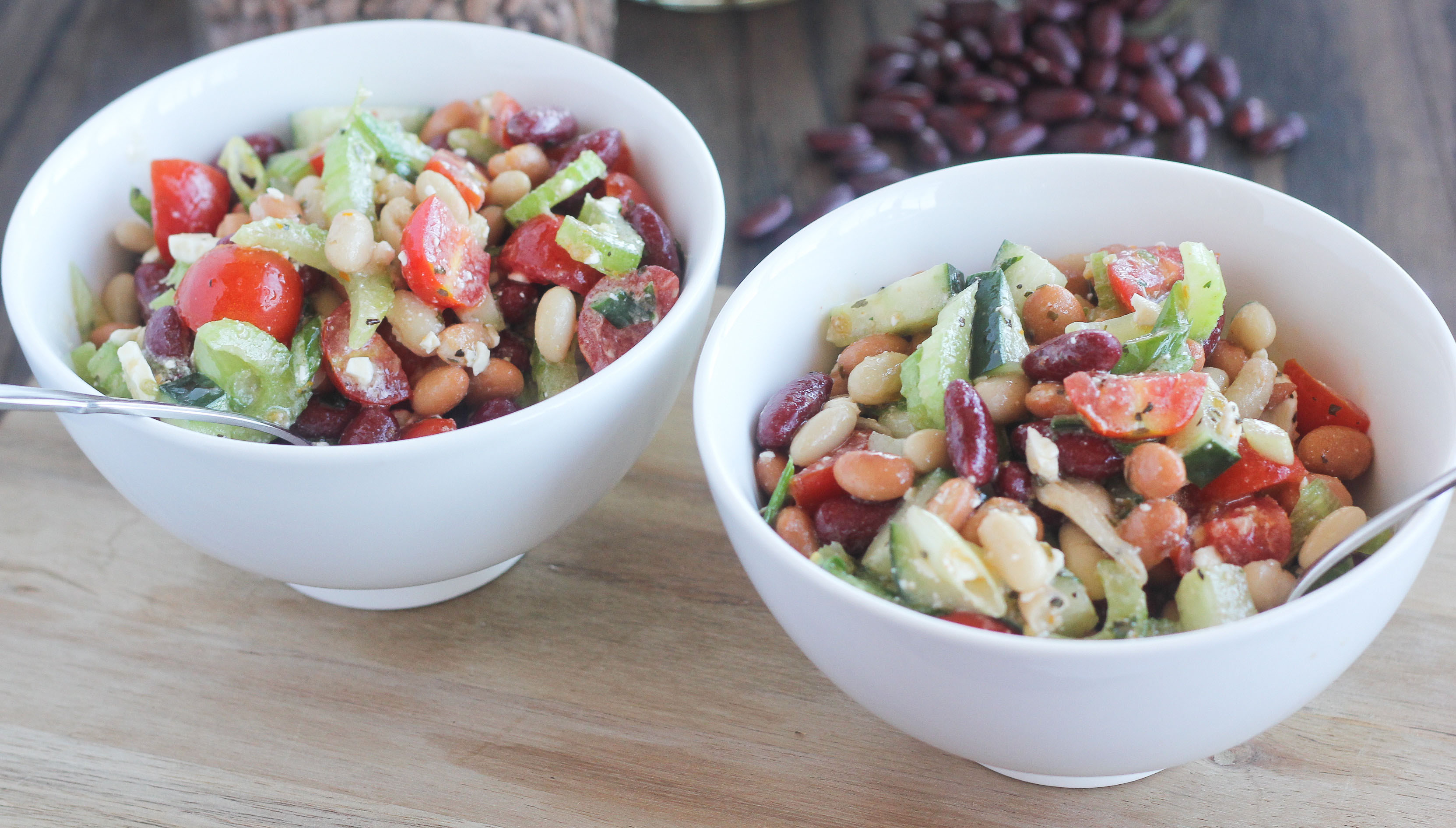 An image depicting the mediterranean bean salad featuring cucumber, tomato, and feta.