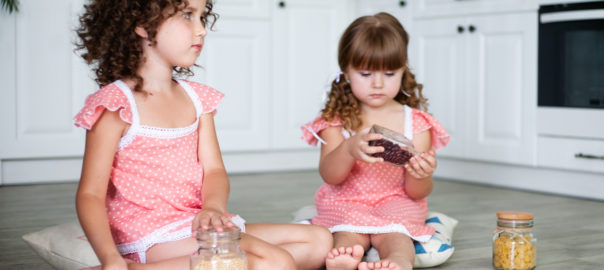 An image depicting girls playing with beans